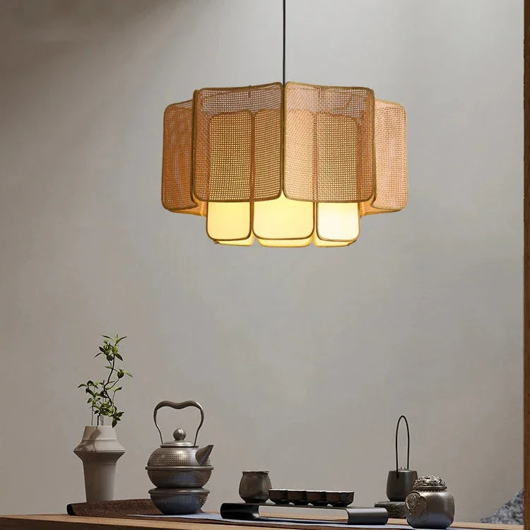 Wicker hanging lamp above a sideboard with vases