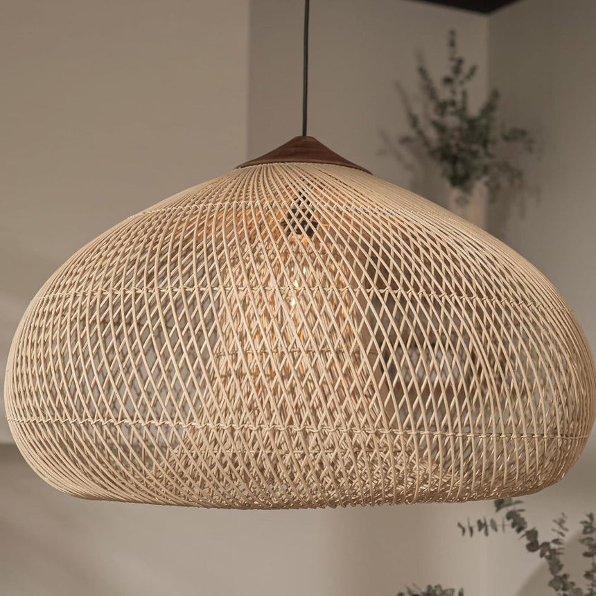 Wicker pendant light in a natural woven dome above a pale interior