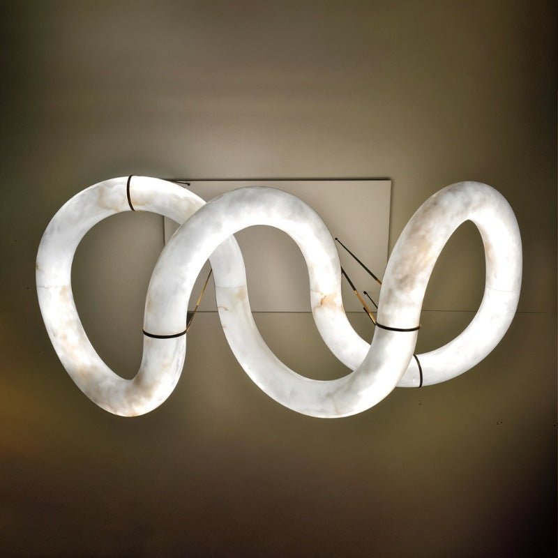 The winding ribbon lit against a dark ground, the loops of stone clearly visible