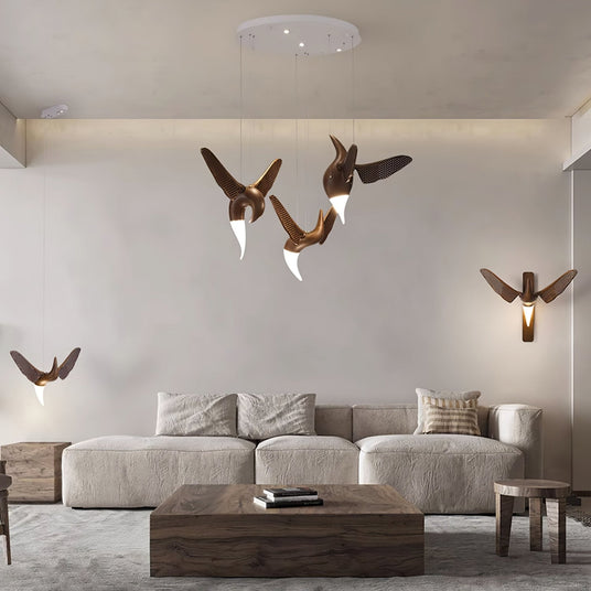 Two sconces lit in a living room above a sofa with low tables beside
