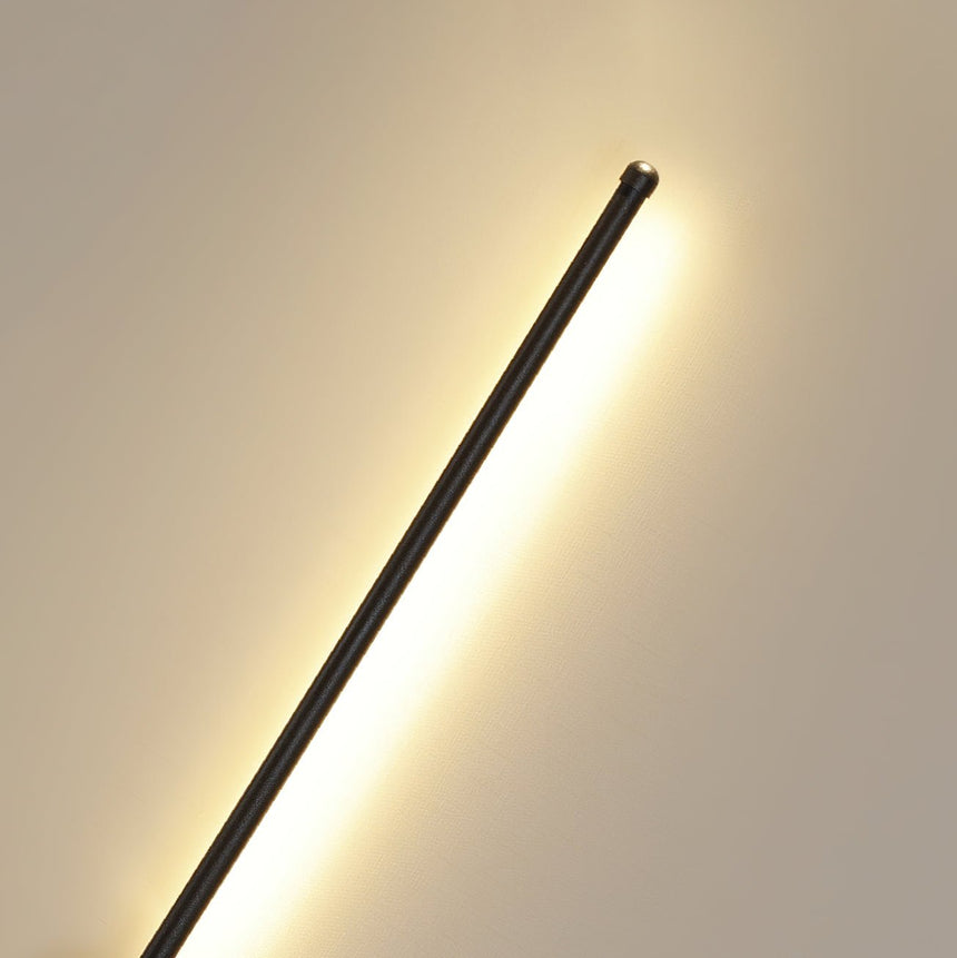 The rod seen at an angle, the lit face turned toward the wall behind it