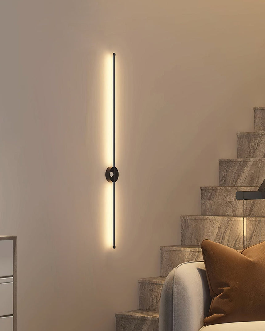Lit on a warm wall beside a staircase and a curved seat with cushions
