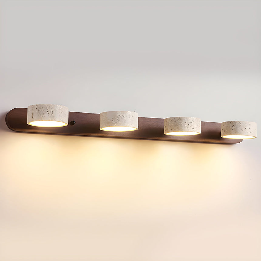 Four travertine discs lit along a long dark walnut bar