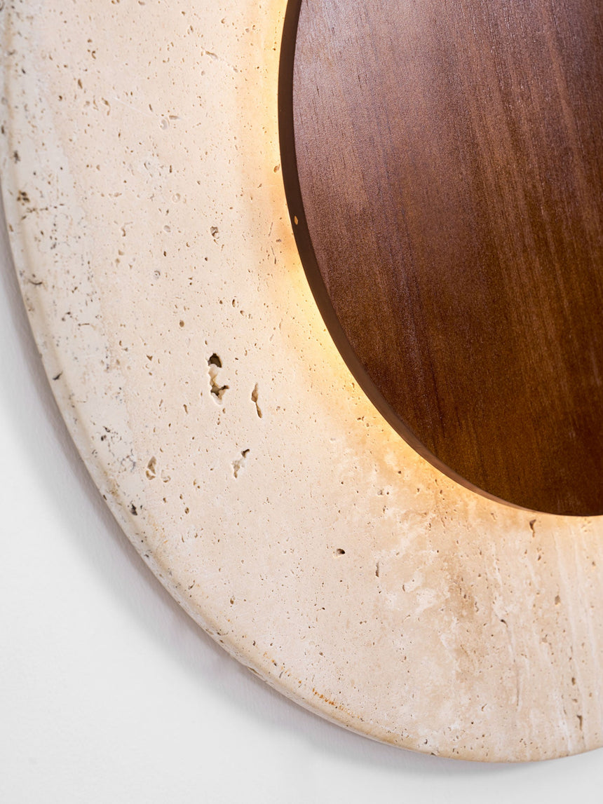 Close view of the porous travertine edge lit from behind the wood disc