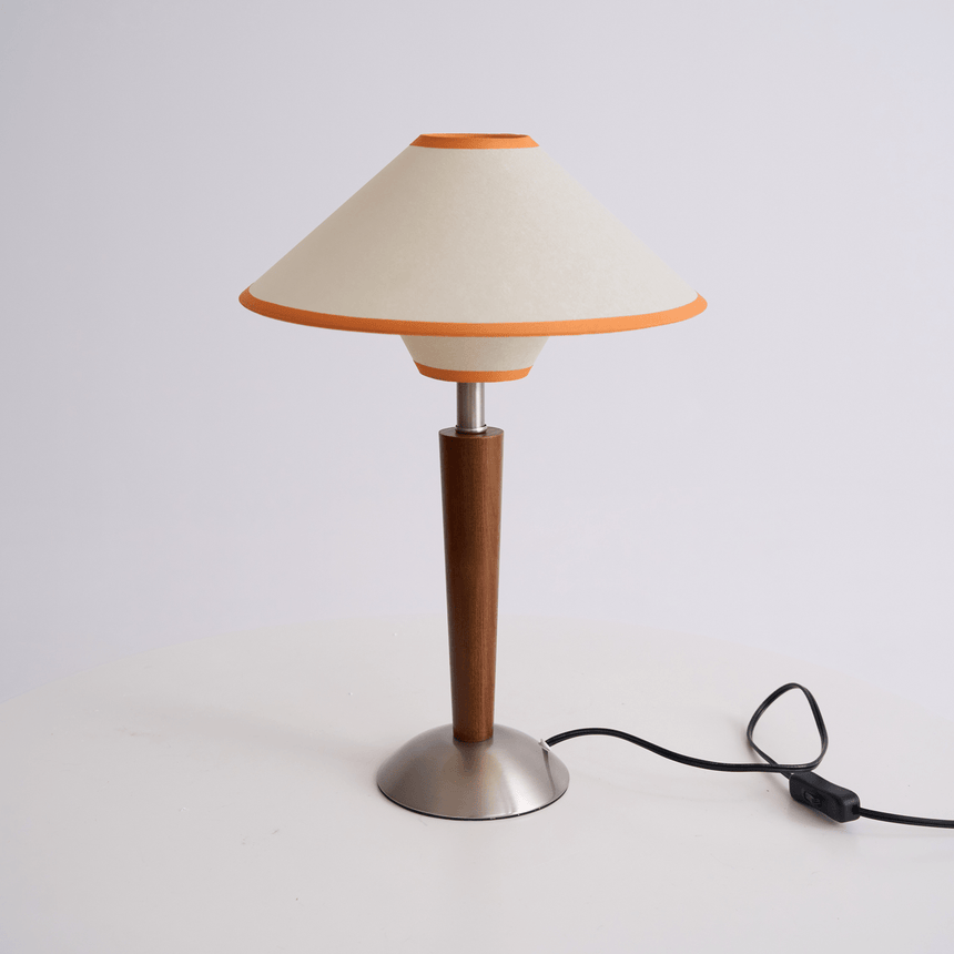 Wood table lamp on a plain background with the cord and inline switch