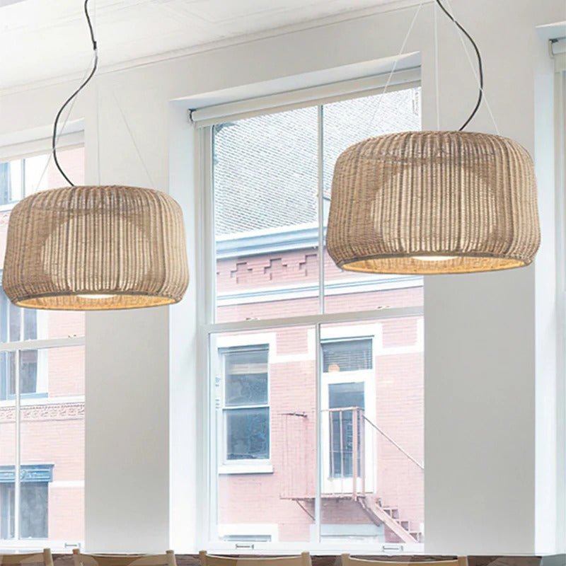 A pair of the woven shades lit in front of a tall window and a brick facade