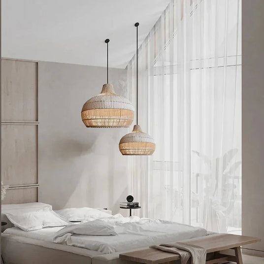 Two woven rattan shades hung beside a bed