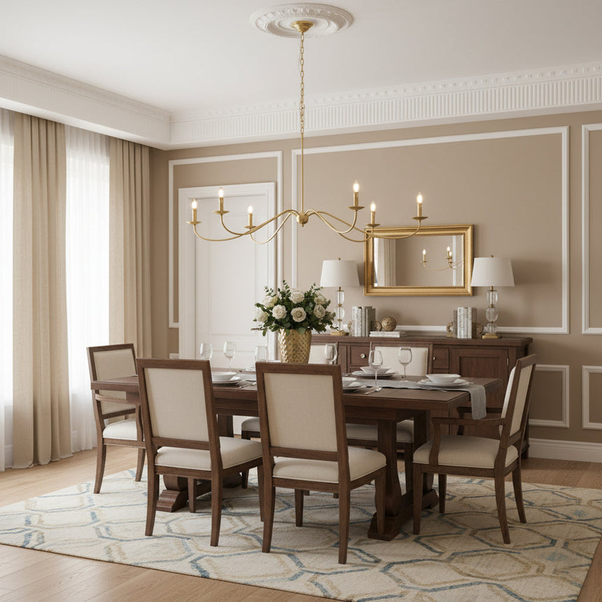 Lit above a dining table and chairs beside a gold framed mirror and sideboard