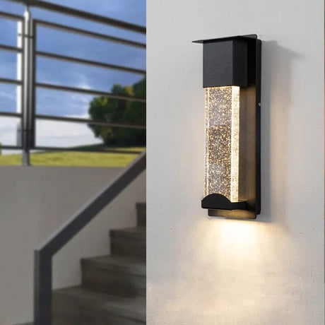 Aluminum LED wall lamp weatherproof design mounted on outdoor patio wall beside garden pathway
