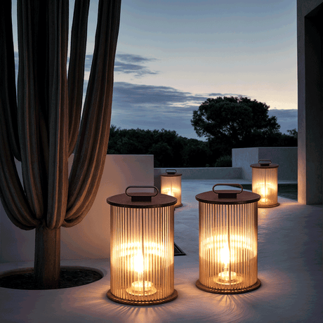 Ribbed glass outdoor lantern light with warm LED glow placed along a modern garden wall at night