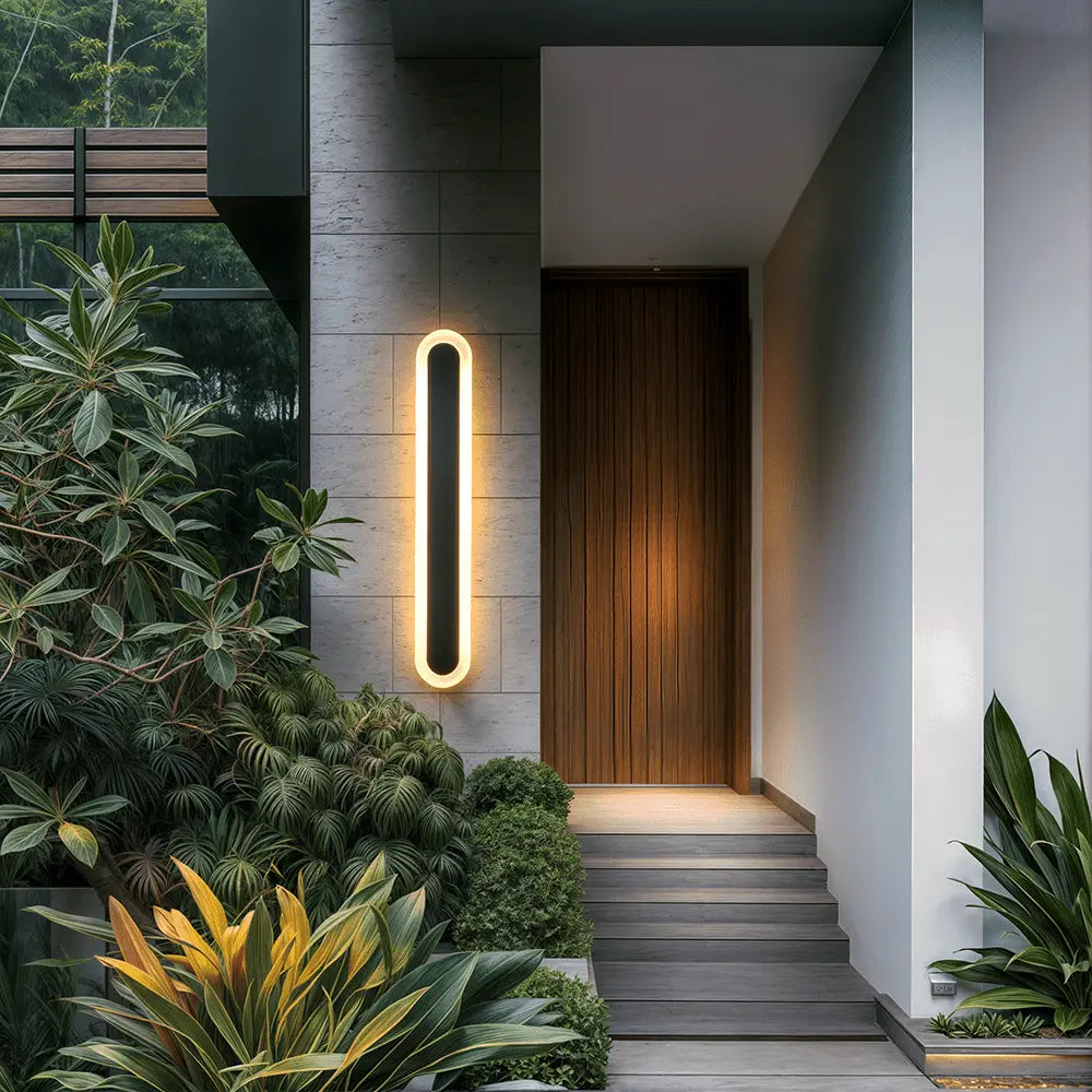 Ravelle black outdoor LED wall strip light mounted on a modern home exterior entryway wall