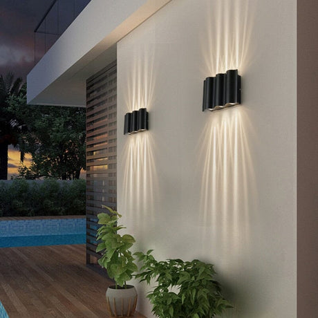Nordic aluminum LED outdoor wall lamp mounted on a modern patio exterior wall with warm glow