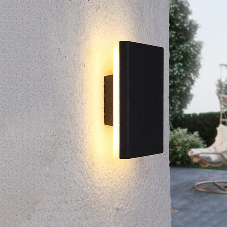 Nordic LED aluminum outdoor wall lamp mounted on exterior wall illuminating a garden patio with warm light