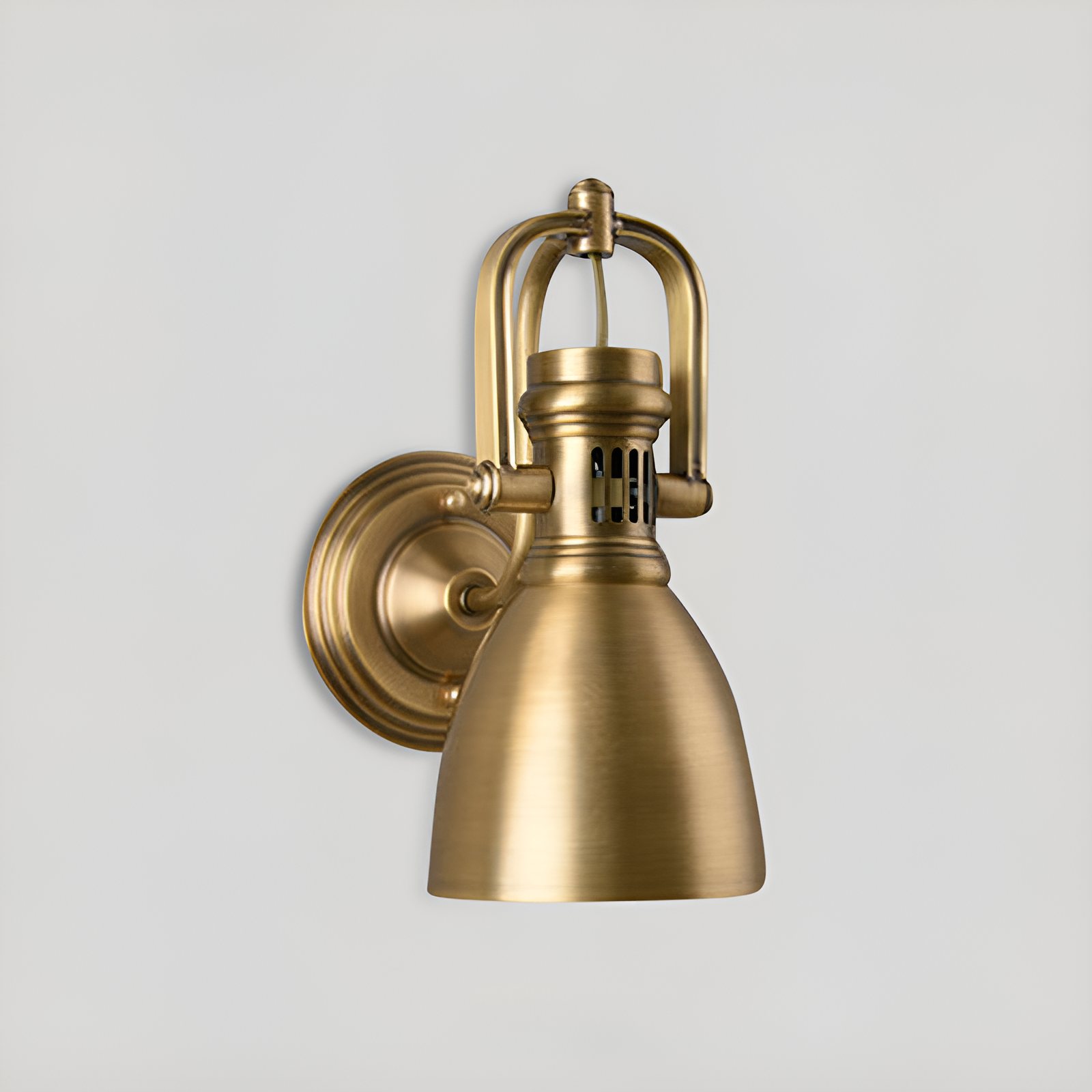 Handcrafted brass wall sconce with frosted glass shade mounted at a covered outdoor entryway with warm LED glow