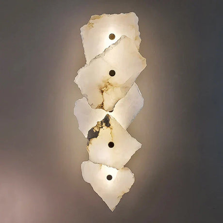 Modern marble wall sconce with copper accents mounted on a neutral bedroom wall with warm LED glow
