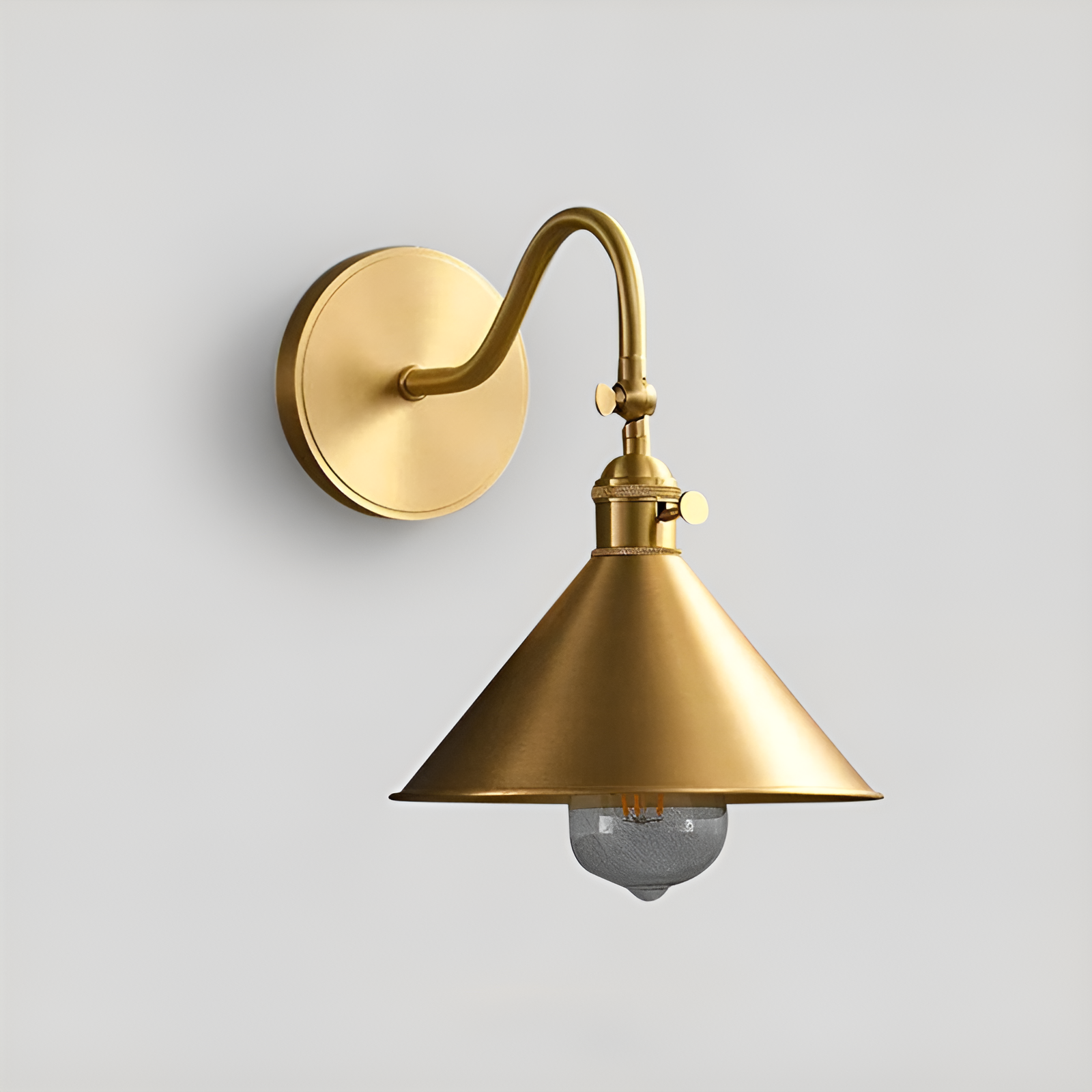 Copper LED wall sconce with adjustable arm and gold finish mounted in a vintage bedroom reading nook
