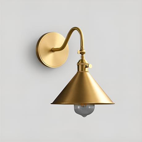 Copper LED wall sconce with adjustable arm and gold finish mounted in a vintage bedroom reading nook