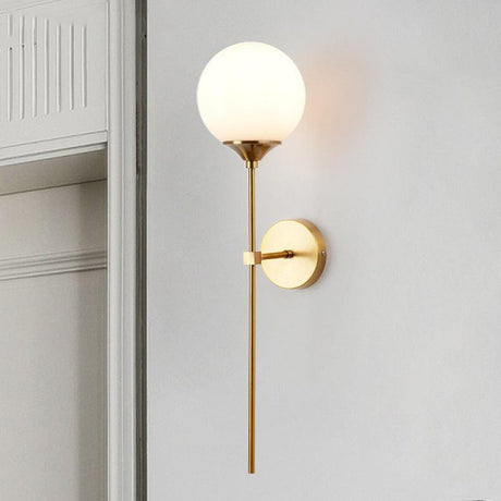 Brass torch wall lamp LED with cognac glass globe mounted on a modern living room wall