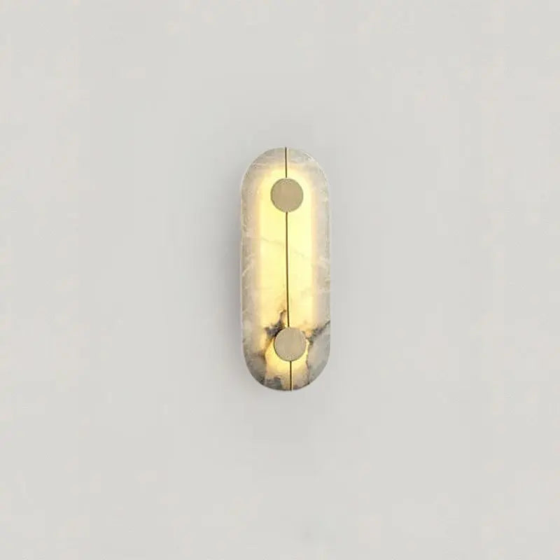 Marbelle marble wall sconce with soft warm LED glow mounted on a neutral living room wall