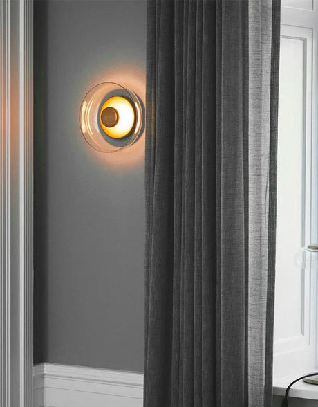 Glass stone LED wall sconce casting soft upward and downward ambient glow in a modern living room accent setting