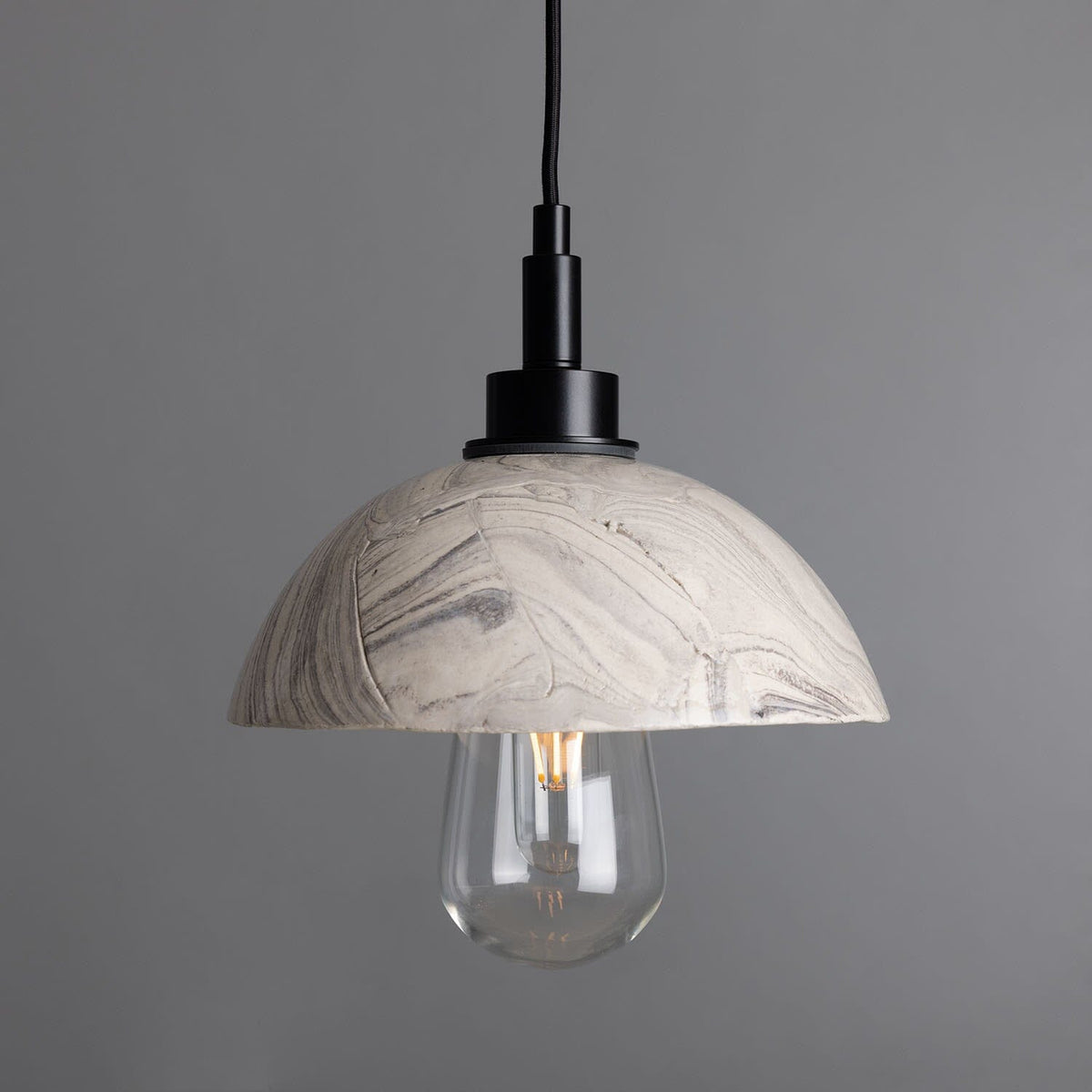 Marbled ceramic pendant hanging from a vaulted ceiling above a kitchen island
