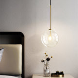 Gold pendant light illuminated in kitchen setting