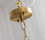 The brass ceiling plate and chain that carry the fitting, seen close
