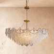 A brass framed chandelier with tiers of pressed clear glass petals lit inside