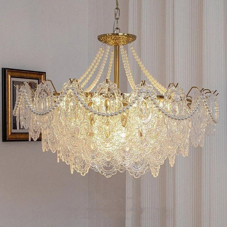 The lit fitting in a pale room beside framed pictures and a sheer curtain