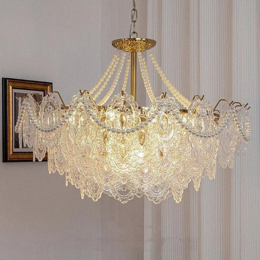 The lit fitting in a pale room beside framed pictures and a sheer curtain