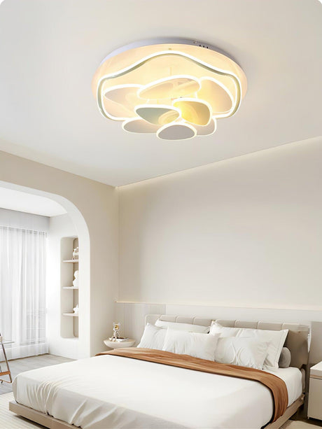 Layered cloud ceiling light above a bed with a wood headboard and shelving