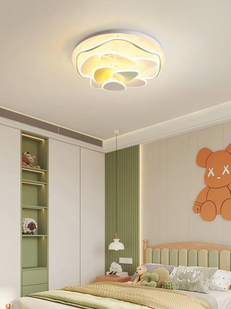 Cloud motif ceiling light above a bed in a child room with green cabinets