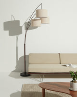 The three arms fanned out over a cream sofa, a plant and a round wood table