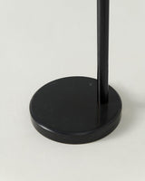 The black pole in the same round base, seen from the side at floor level
