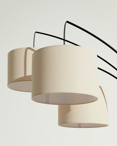 The same three drums on black arms, the lit interior of one shade visible