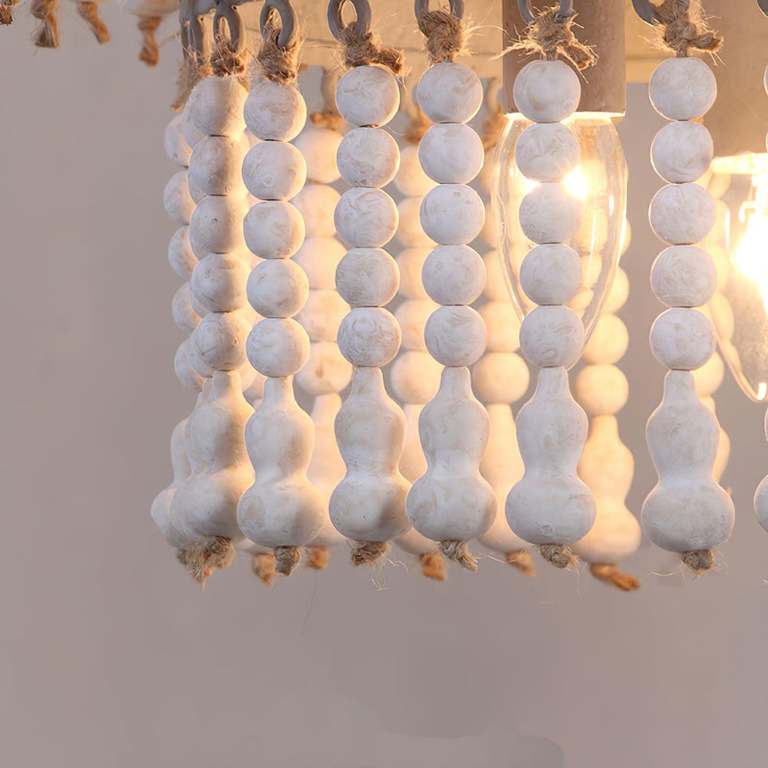 The white bead strands hanging close together with a lamp glowing behind