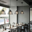 Black iron pendant light with open cage silhouette