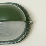 Metal frame wall sconce with glass shade close-up