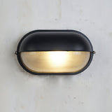 Wall lamp casting glow on exterior brick wall