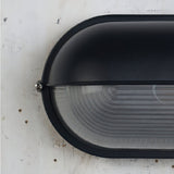 Oval glass wall light for patio evening ambiance