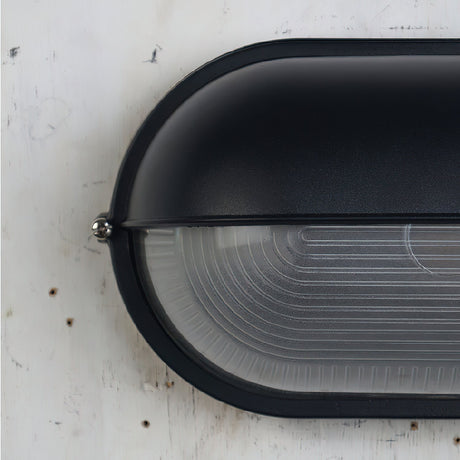 Oval glass wall light for patio evening ambiance
