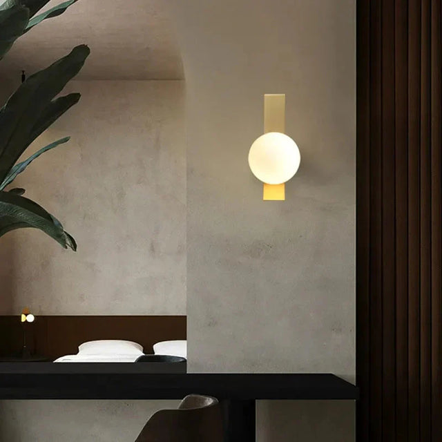 Glass stone wall lamp with gilded finish and warm LED glow