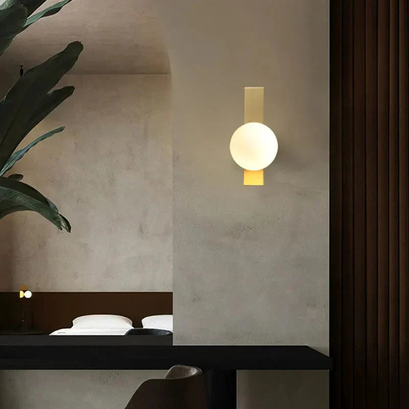 Glass stone wall lamp with gilded finish and warm LED glow