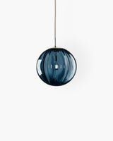 Amber glass pendant light installed above dining table - OpalDwell