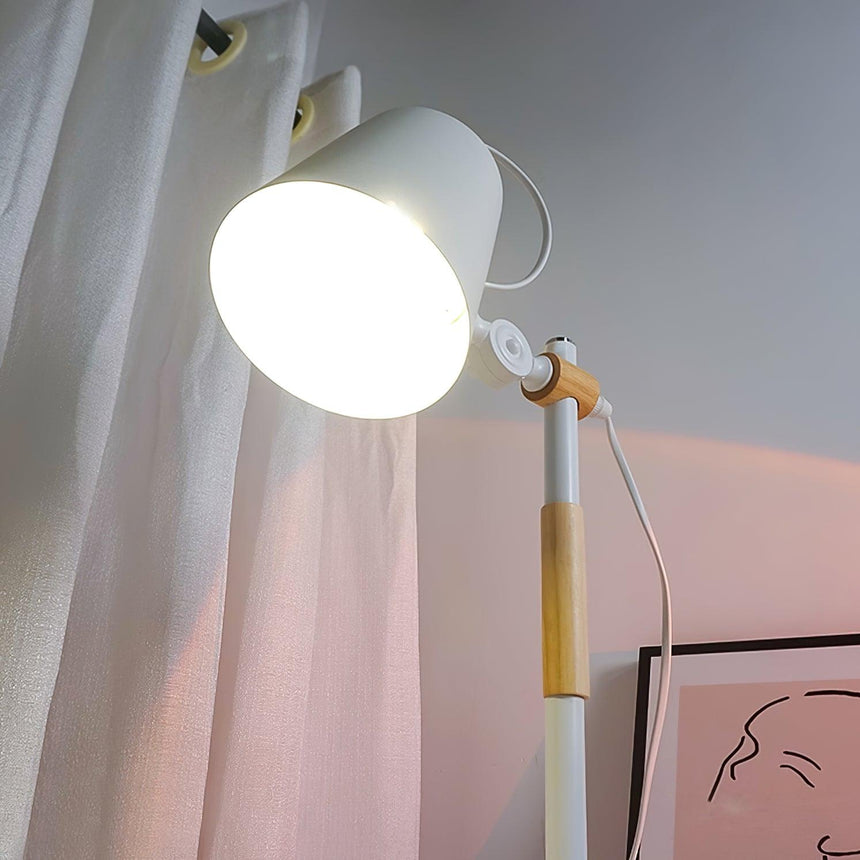 Close view of the lit bulb below the tilted white metal head