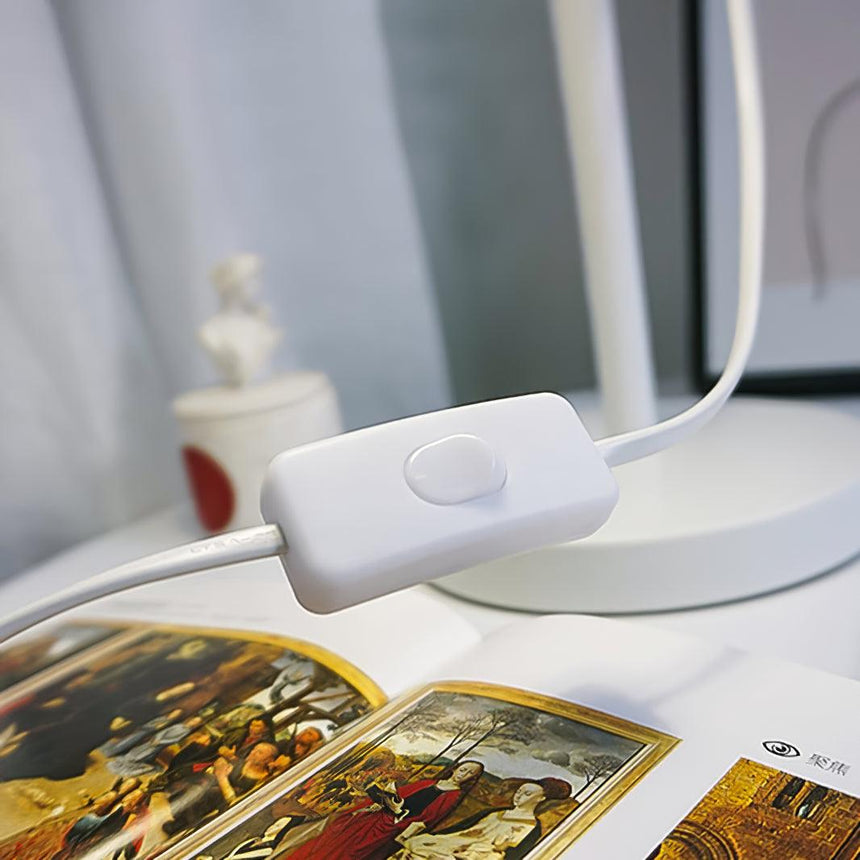 Close view of the rocker switch on the white cord beside a book