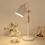 Adjustable desk lamp lit on a desk beside a small basket of flowers