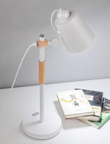 Adjustable desk lamp on a white surface beside two stacked books