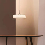 Flat drum shade above a table in a dark room