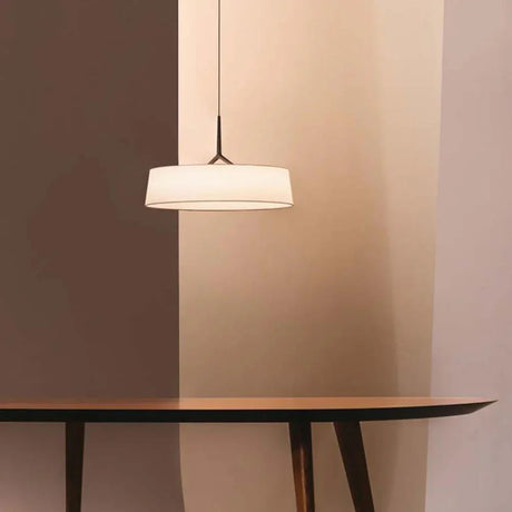 Flat drum shade above a table in a dark room